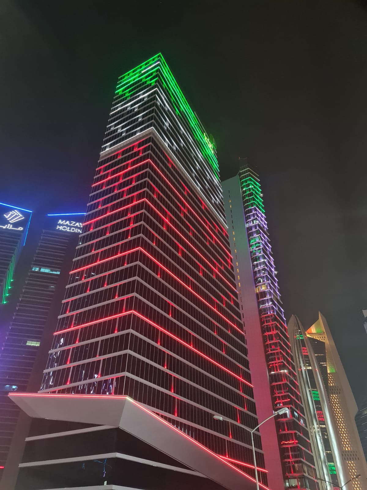 KBT Tower, Kuwait City, lit at night in green, white and red across the full height of the façade